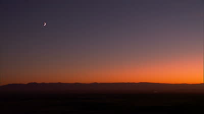 stock-footage-white-crescent-moon-in-rosy-sunset-sky